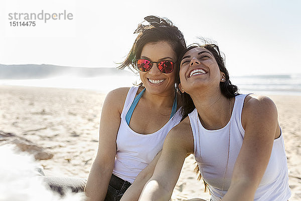 Porträt von zwei glücklichen Freundinnen am Strand