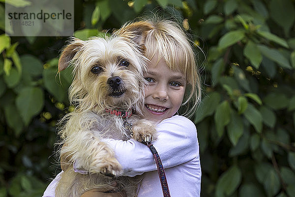 Porträt eines glücklichen kleinen Mädchens mit ihrem Hund