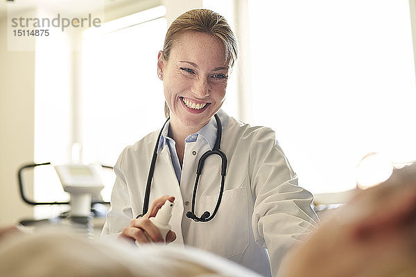 Lächelnde Ärztin bereitet in der medizinischen Praxis eine Blutentnahme bei einem Patienten vor
