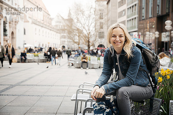 Porträt einer lächelnden blonden Frau mit Gepäck in der Stadt  München  Deutschland