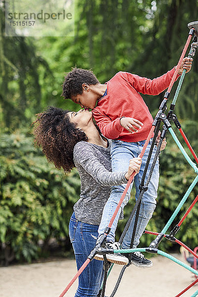 Mutter und Sohn spielen auf einem Spielplatz in einem Park  klettern in einer Kletterhalle im Dschungel