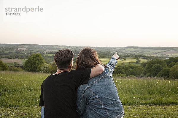 Rückenansicht von glücklichen jungen Liebenden in der Natur beim Anschauen