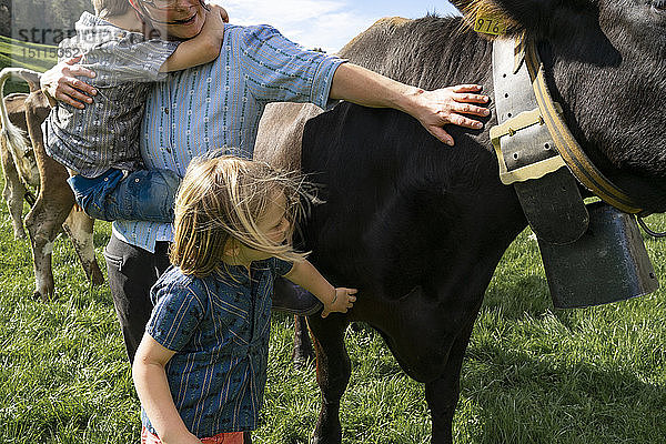 Mutter mit zwei Kindern auf der Kuhweide