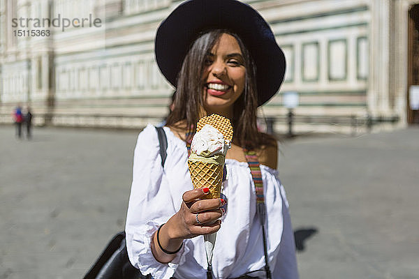 Italien  Florenz  Piazza del Duomo  glücklicher junger Tourist hält Eiswaffel