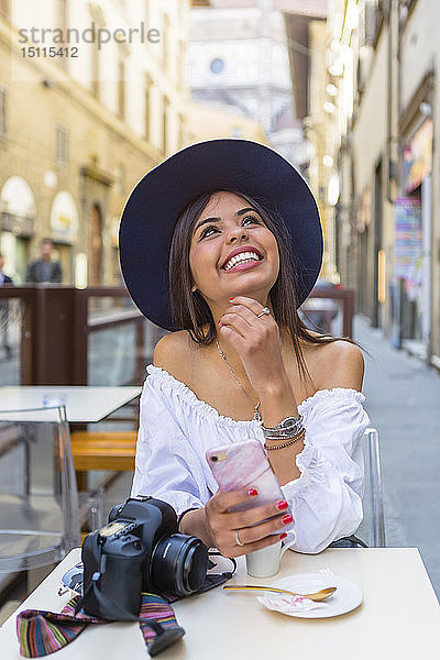 Italien  Florenz  Porträt eines glücklichen jungen Touristen  der im Straßencafé Espresso trinkt