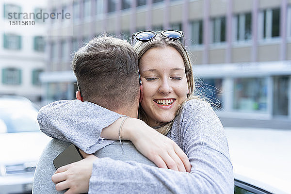 Porträt einer glücklichen jungen Frau  die ihren Freund umarmt