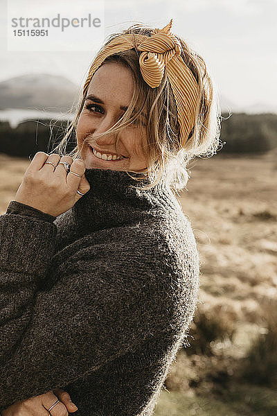 Großbritannien  Schottland  Loch Lomond und der Trossachs-Nationalpark  Porträt einer lächelnden jungen Frau in einer ländlichen Landschaft