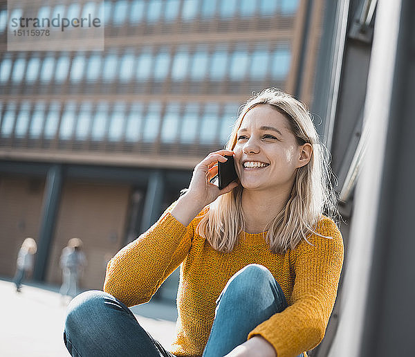 Porträt einer glücklichen jungen Frau am Telefon