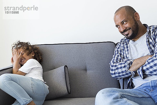 Glücklicher Vater und Tochter sitzen zu Hause auf der Couch