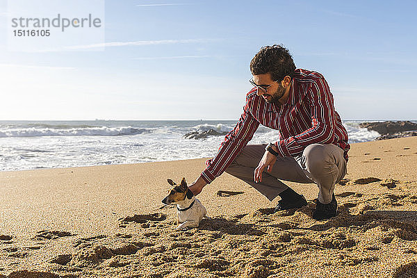 Portugal  Porto  junger Mann streichelt seinen Hund am Strand