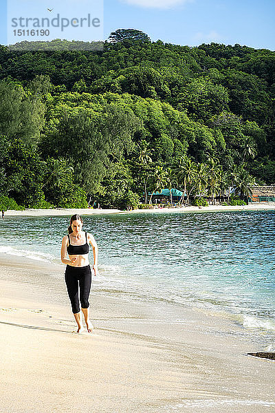Seychellen  Mahe  Takamaka Beach  reife Frau joggt am Strand