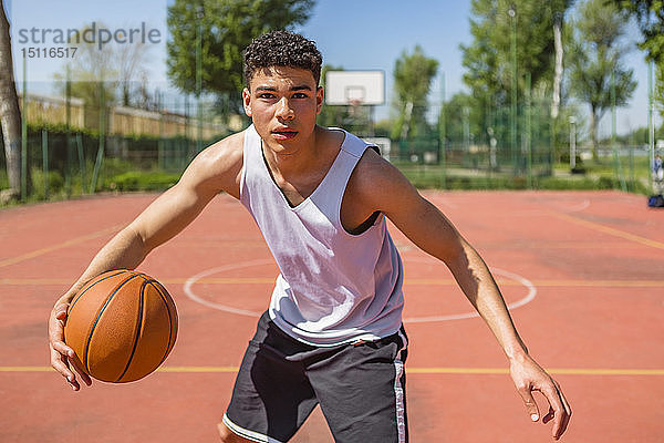 Junger Mann spielt Basketball