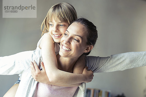 Mutter und Tochter spielen zu Hause und tun so  als würden sie fliegen