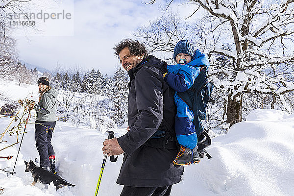 Vater mit Sohn im Kinderwagen  Mutter und Hund im Winter in Oberammergau