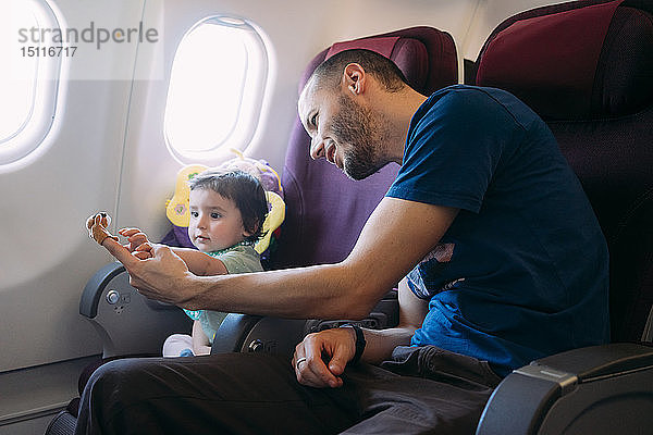 Vater spielt mit seiner kleinen Tochter im Flugzeug