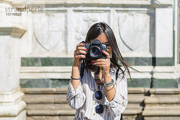 Italien  Florenz  junger Tourist beim Fotografieren mit der Kamera