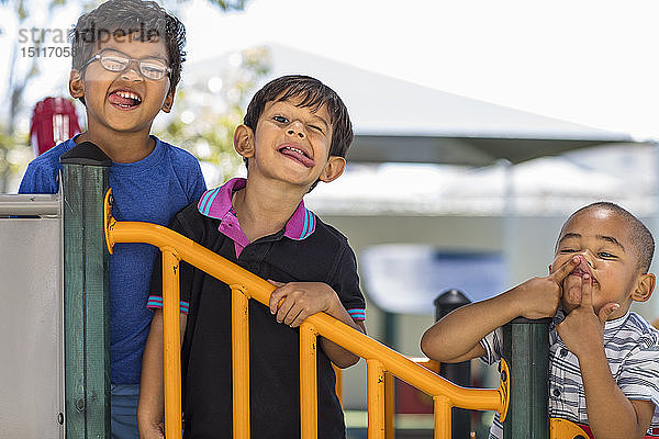 Porträt von verspielten Jungen  die im Kindergarten Grimassen schneiden