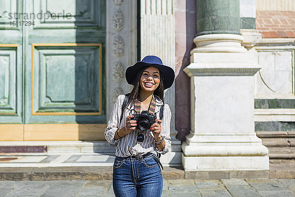 Italien  Florenz  Porträt eines glücklichen jungen Touristen mit Kamera