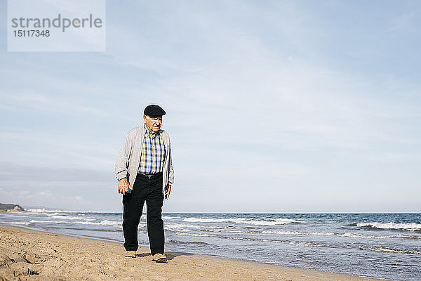 Älterer Mann beim Strandspaziergang im Frühling