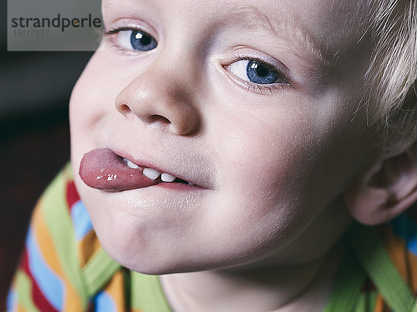 Porträt eines kleinen Jungen mit herausgestreckter Zunge