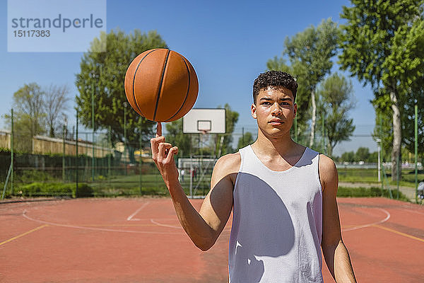 Junger Mann spielt mit Basketball
