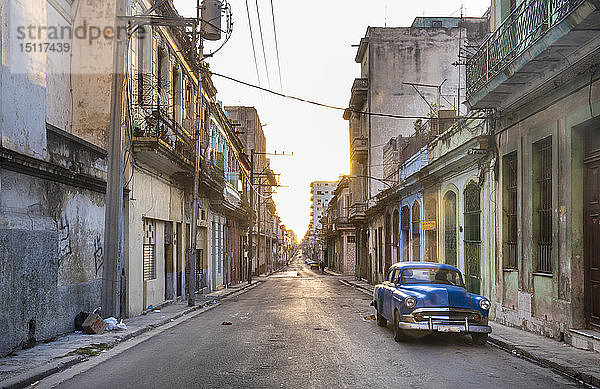 Blauer Oldtimer auf leerer Straße in der Abenddämmerung geparkt  Havanna  Kuba