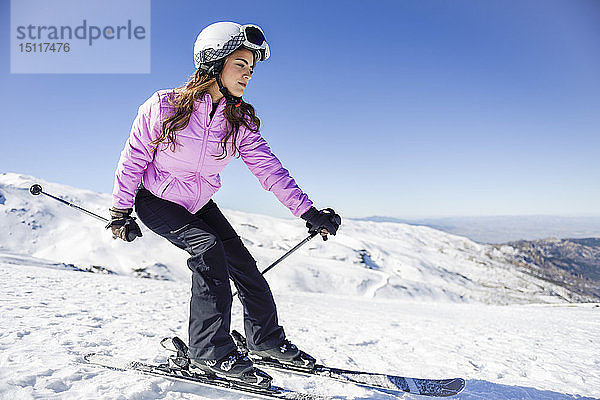 Frau fährt Ski unter blauem Himmel  Sierra Nevada  Andalusien  Spanien