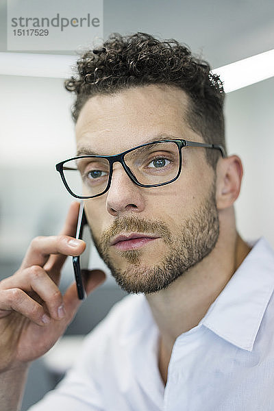 Porträt eines Geschäftsmannes am Handy im Büro
