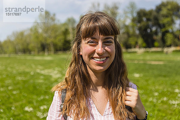 Lächelnde junge Frau in einem Park  Porträt