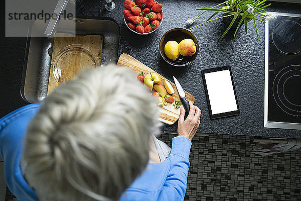 Frau hackt Früchte in ihrer Küche  Nahaufnahme