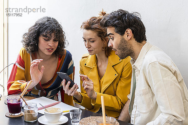 Freunde mit Notebook und Handy in einem Cafe