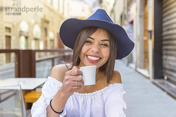 Italien  Florenz  Porträt eines glücklichen jungen Touristen  der im Straßencafé Espresso trinkt