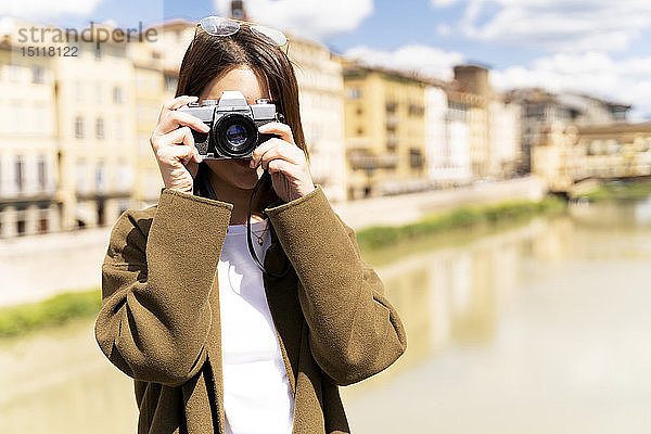 Italien  Florenz  junge Touristin beim Fotografieren in Ponte Vecchio