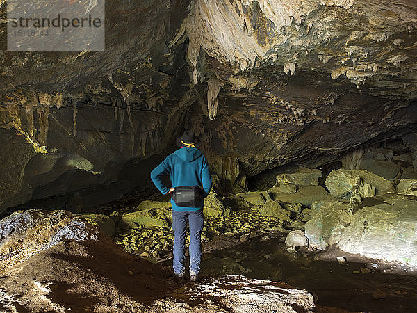 Spanien  Baskenland  Euskadi  älterer Mann beim Betrachten der Felsen in der Höhle von Baltzola