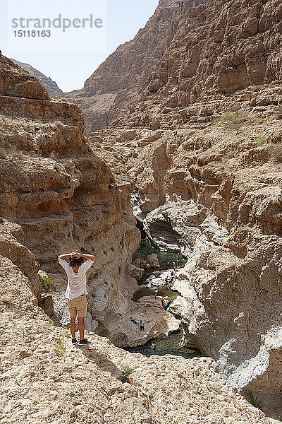 Mann genießt die Aussicht über Wadi Shab  Oman
