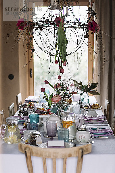 Gedeckter Tisch mit Blumenschmuck im Frühling