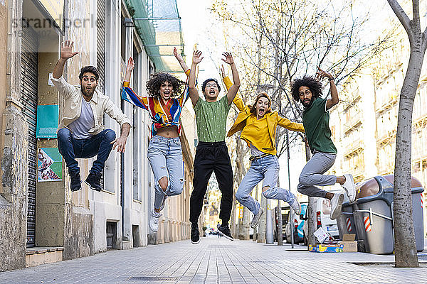 Fröhliche Gruppe von Freunden amüsiert sich in der Stadt beim Springen aus der Luft