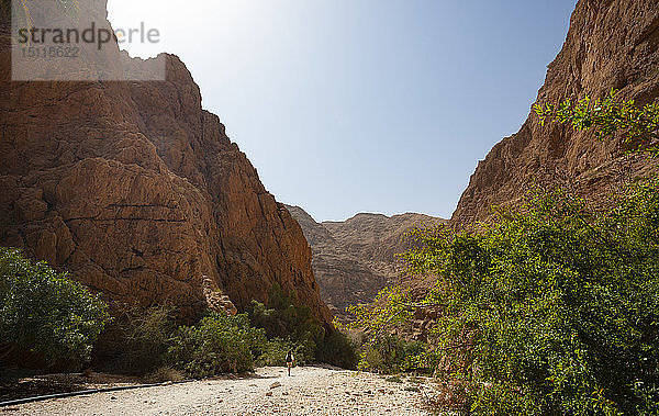 Mann geht durch Felsen  Wadi Shab  Oman
