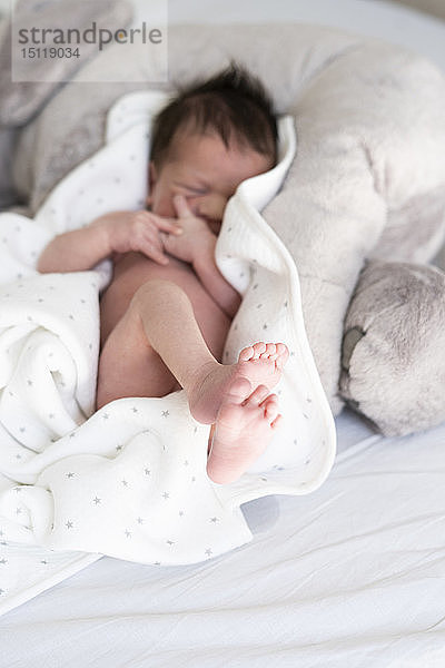 Neugeborenes Baby liegt auf einer Decke im Bett