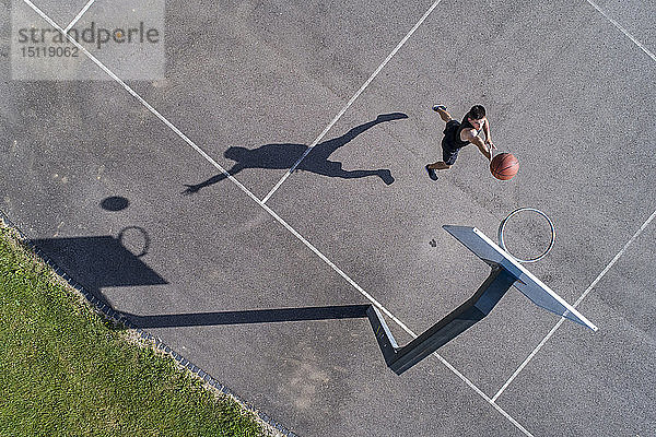 Luftaufnahme eines jungen Mannes beim Basketball spielen