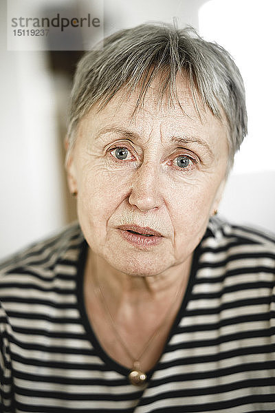 Porträt einer älteren Frau mit kurzen Haaren  die respektabel in die Kamera schaut
