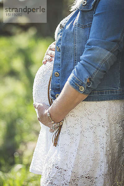 Schwangere Frau hält ihren Bauch  Nahaufnahme