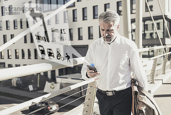 Älterer Geschäftsmann benutzt Mobiltelefon zur Navigation in der Stadt