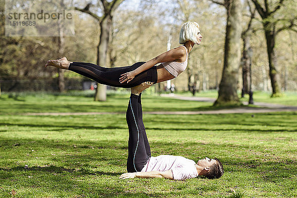 Junges Paar macht Yoga-Akrobatik in einem städtischen Park