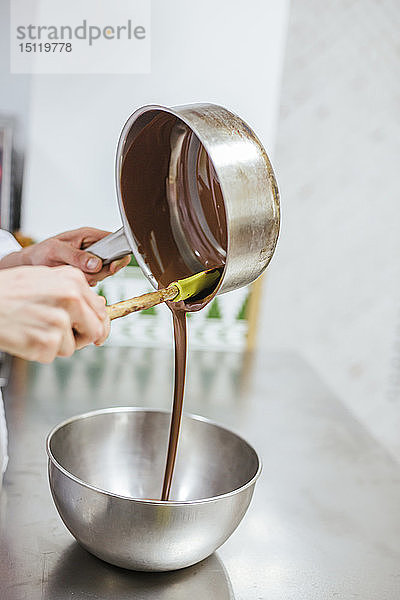 Junior-Chefkoch bereitet ein Dessert zu  Schüssel mit Schokoladensauce