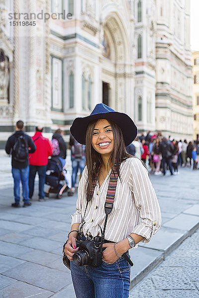 Italien  Florenz  Piazza del Duomo  Porträt eines glücklichen jungen Touristen mit Kamera