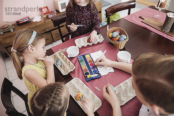 Kinder malen zu Hause Ostereier auf den Tisch