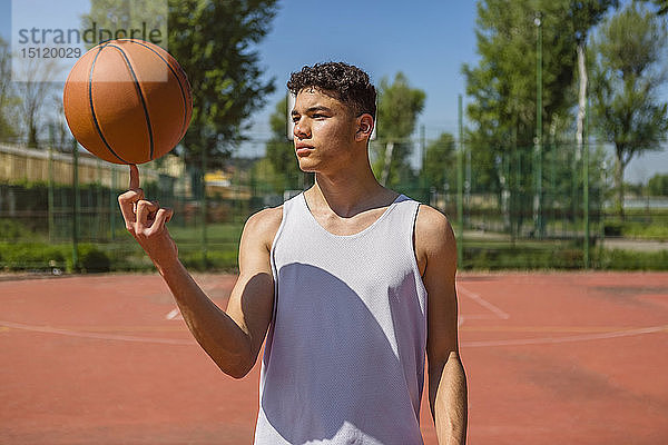 Junger Mann spielt mit Basketball