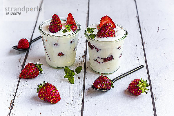 Joghurt mit frischen Erdbeeren und Minze auf Holz