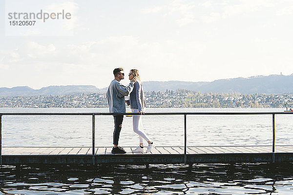 Verliebtes junges Paar auf dem Steg am Zürichsee stehend  Zürich  Schweiz